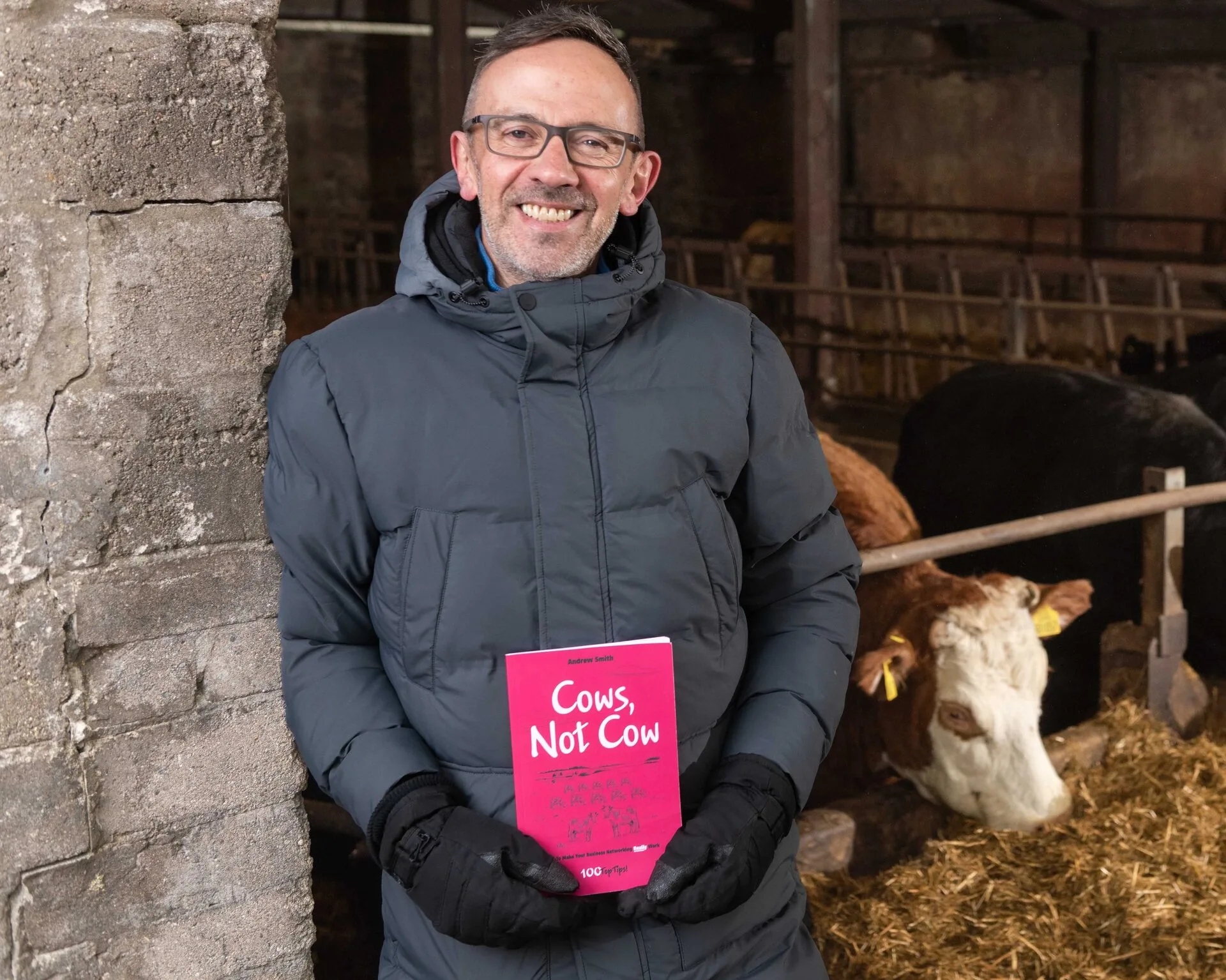 Andrew Smith holding Cows Not Cow book with cows